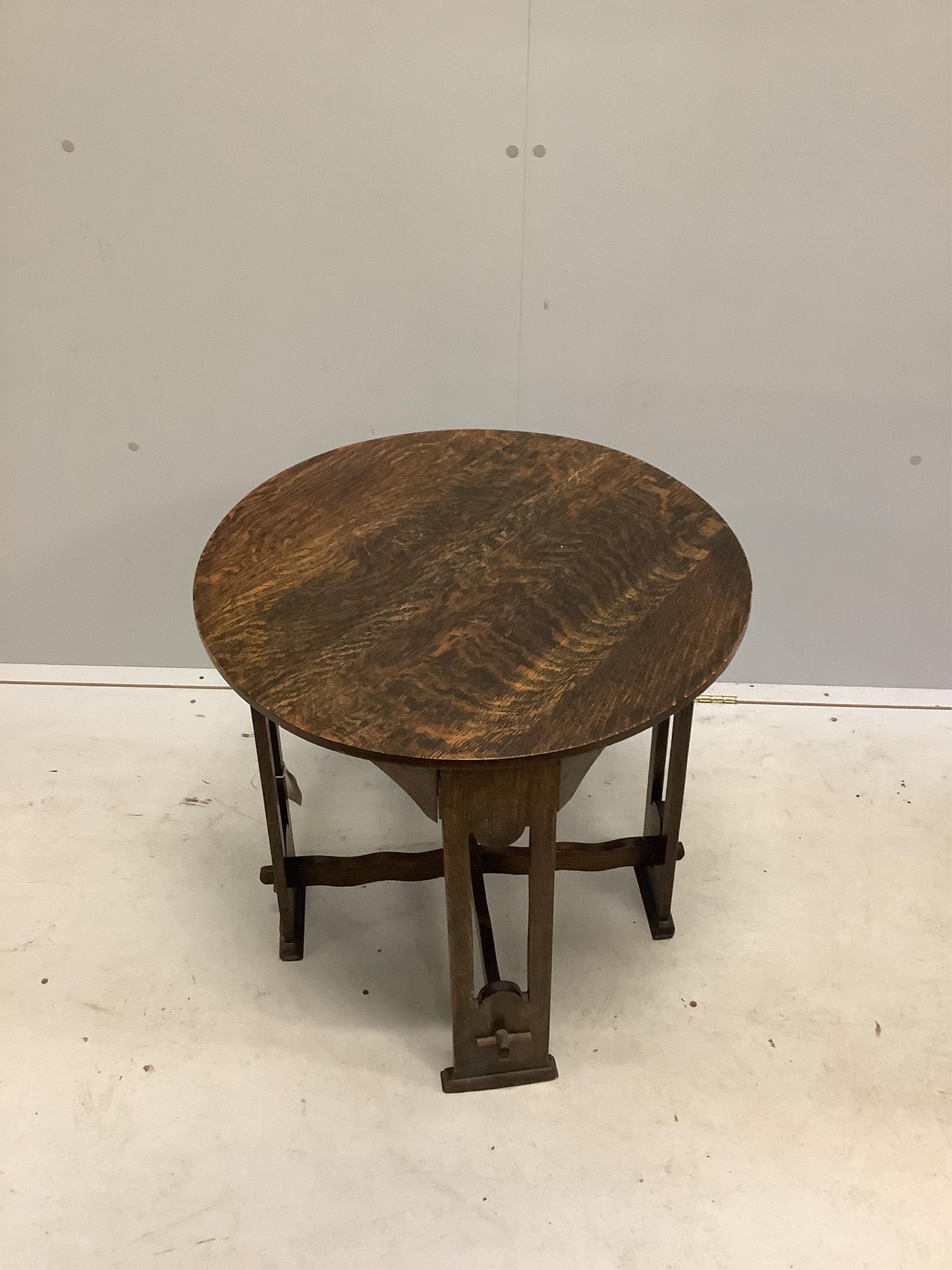 An Arts & Crafts circular oak occasional table, diameter 61cm, height 61cm. Condition - fair